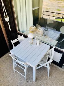 einen weißen Tisch mit zwei Stühlen und einem Fenster in der Unterkunft Strandhafer in Wendtorf