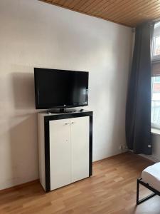 a flat screen tv sitting on top of a white cabinet at Ferien Wohnung Elmaci in Itzehoe