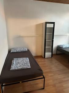 ein kleines Zimmer mit 2 Betten und einem Spiegel in der Unterkunft Ferien Wohnung Elmaci in Itzehoe