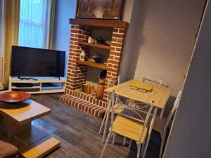a living room with a table and a fireplace at Ferndale House-Huku Kwetu Luton -Spacious 4 Bedroom House - Suitable & Affordable Group Accommodation - Business Travellers in Luton
