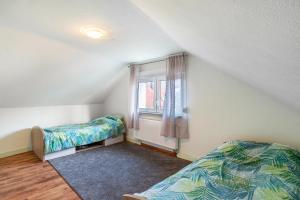 a bedroom with two beds and a window at Haus am Bach in Haueneberstein