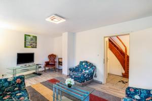 a living room with two chairs and a tv at Haus am Bach in Haueneberstein