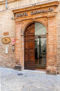 een toegang tot een hotel met een grote houten deur bij Hotel Grimaldi in Treia