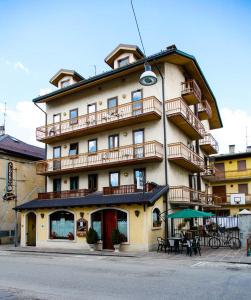 ein großes Gebäude mit Tischen und Stühlen davor in der Unterkunft Albergo Speranza in Asiago