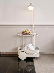 a white cart with a plate of fruit on it at Flemings Hotel München-City in Munich