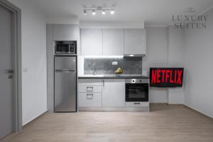 una cocina con armarios blancos y electrodomésticos en una habitación en WeStay Apartments, The Luxury Suites en Tesalónica