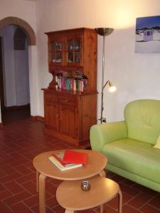 een woonkamer met een groene bank en een tafel bij Casa Le Basse - Vetulonia in Gavorrano