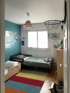 - une chambre avec 2 lits et un panier de basket dans l'établissement Appartement familiale Paris - Mairie des Lilas, aux Lilas