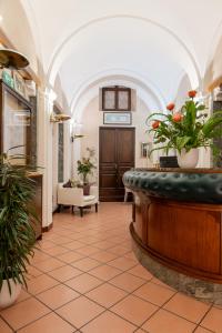 een lobby met een wachtruimte met potplanten bij Hotel Grimaldi in Treia