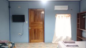 a room with a blue wall with a door and a television at Hotel EL BOSQUE in Talamanca