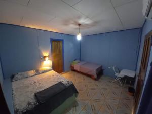a bedroom with two beds and a blue wall at Hotel EL BOSQUE in Talamanca