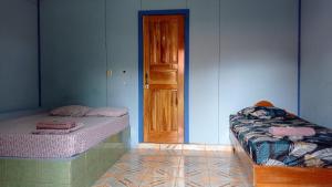 a room with two beds and a wooden door at Hotel EL BOSQUE in Talamanca