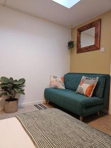 a living room with a green couch and a mirror at Fulham 2 bedroom apartment in London