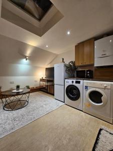 a kitchen with a washer and dryer and a table at Fulham 2 bedroom apartment in London