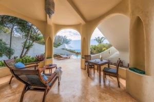 d'une terrasse intérieure avec des chaises et des tables et une vue sur l'océan. dans l'établissement Kilindi Zanzibar, à Kendwa