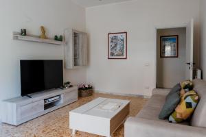 sala de estar con sofá y TV de pantalla plana en La Casa di Betty en Lido di Ostia