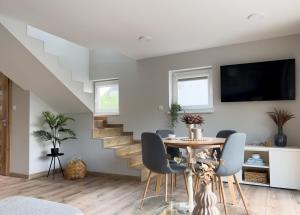 une salle à manger avec une table et un escalier dans l'établissement Garden House - OSTOYA, à Jasionka