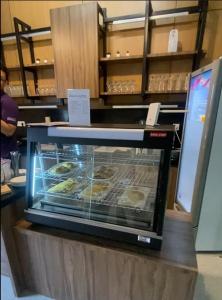 a display case in a bakery with pastries in it at Daima Suites Margonda in Perhentian Pondoktjina