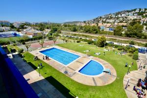 een uitzicht over een park met een zwembad bij Marina Duplex by Hello Homes Sitges in Sitges