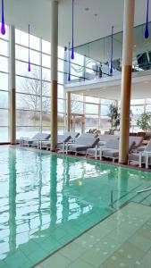 a swimming pool in a building with chairs at Spa Resort Styria- ADULTS ONLY in Bad Waltersdorf
