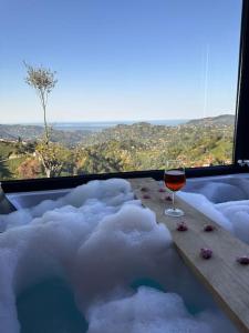 a glass of wine sitting on a bathtub covered in snow at Hills Wooden House in Cayeli