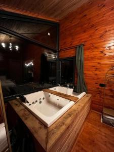 ein Badezimmer mit einer großen Badewanne in einem Holzzimmer in der Unterkunft Hills Wooden House in Cayeli