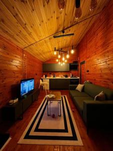 a living room with a couch and a tv at Hills Wooden House in Cayeli