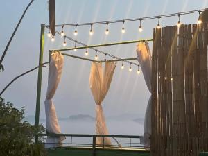een tent met gordijnen en verlichting voor een raam bij Bangmara Hill in Takua Pa