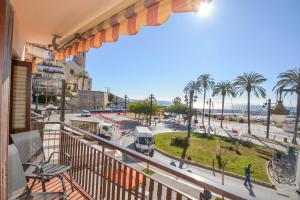 balcón con vistas a la calle y a las palmeras en Soleil by Hello Homes Sitges, en Sitges