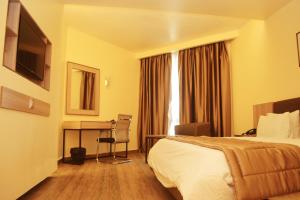 Habitación de hotel con cama y escritorio en Hotel Presidential, en Port Harcourt
