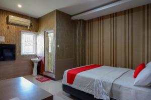 a bedroom with a large bed and a television at RedDoorz at Jalan Emmy Saelan Palu in Palu
