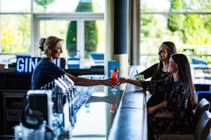 Duas mulheres estão a apertar as mãos num bar. em Spa Resort Styria- ADULTS ONLY em Bad Waltersdorf