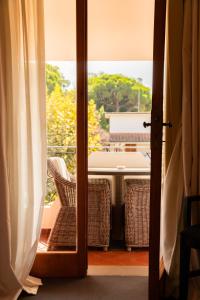 uma porta aberta para uma varanda com uma mesa e cadeiras em California Park Hotel em Forte dei Marmi