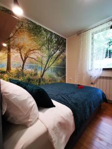 a bedroom with a bed with a painting on the wall at Holiday home Sovica in Vrbovsko