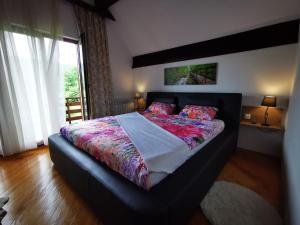a bedroom with a large bed with a large window at Holiday home Sovica in Vrbovsko