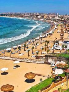 a beach with umbrellas and people on the beach at كبائن النصر المعمورة الشاطىء 7 in Alexandria