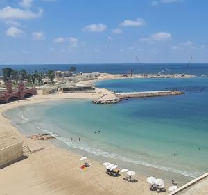 a beach with chairs and umbrellas in the water at كبائن النصر المعمورة الشاطىء 7 in Alexandria