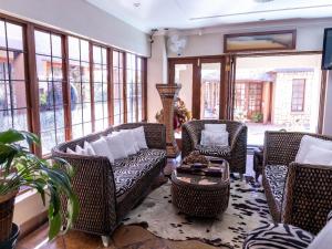 a living room with wicker chairs and a couch at The Orion in Middelburg