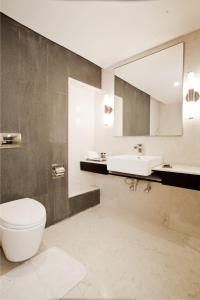 La salle de bains est pourvue de toilettes, d'un lavabo et d'un miroir. dans l'établissement Ebony Boutique Hotel, à Hyderabad