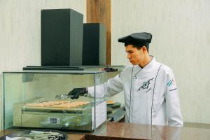 a chef preparing hot dogs in a kitchen at FAYZ in Urganch