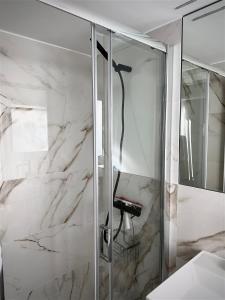 y baño con ducha y paredes de mármol. en Fisherhouse23, en Câmara de Lobos