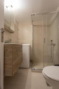 ein Bad mit einer Dusche, einem WC und einem Waschbecken in der Unterkunft Glyfada downtown in Athen