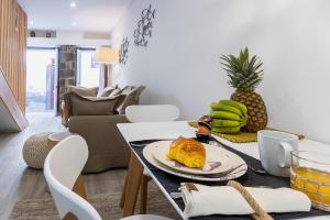 ein Wohnzimmer mit einem Tisch und einem Teller mit Lebensmitteln in der Unterkunft Fisherhouse23 in Câmara de Lobos