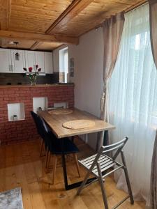 a table and chairs in a kitchen with a window at Casa Iuliana in Valcea