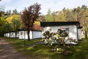 uma casa branca com flores à frente em Ferienresort Damerow em Ostseebad Koserow