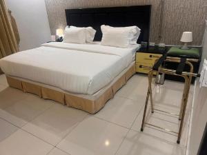 um quarto com uma cama com uma cadeira e uma secretária em اجنحة أروى سويتس الدمام Arwa Suites Dammam em Dammam