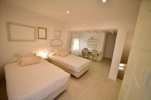 a bedroom with two beds and a table and chairs at CASABLANCA in Jávea