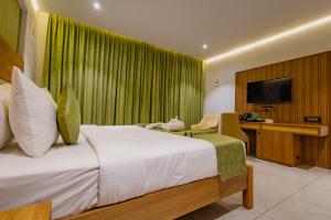een hotelkamer met een bed en een televisie bij Vanya in Bangalore