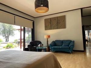 a bedroom with a bed and two chairs and a table at Oasis On Lily with OWN Pool in Johannesburg +83 photos