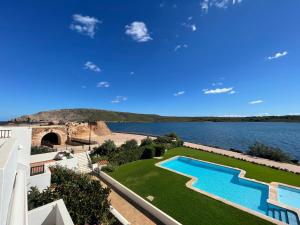 een afbeelding van een huis met een zwembad en een meer bij ES CASTELL 2 5 by SOM Menorca in Fornells